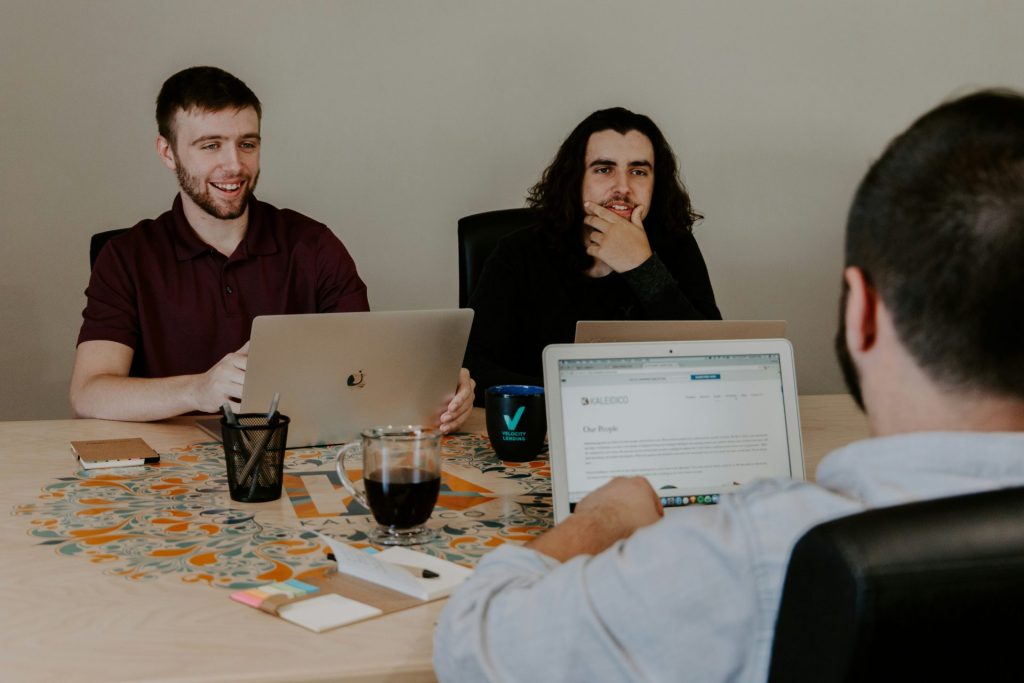 Three colleagues brainstorming, relaxed, working, and laughing